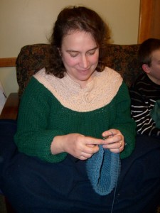 Christine Guest crochetting on the couch